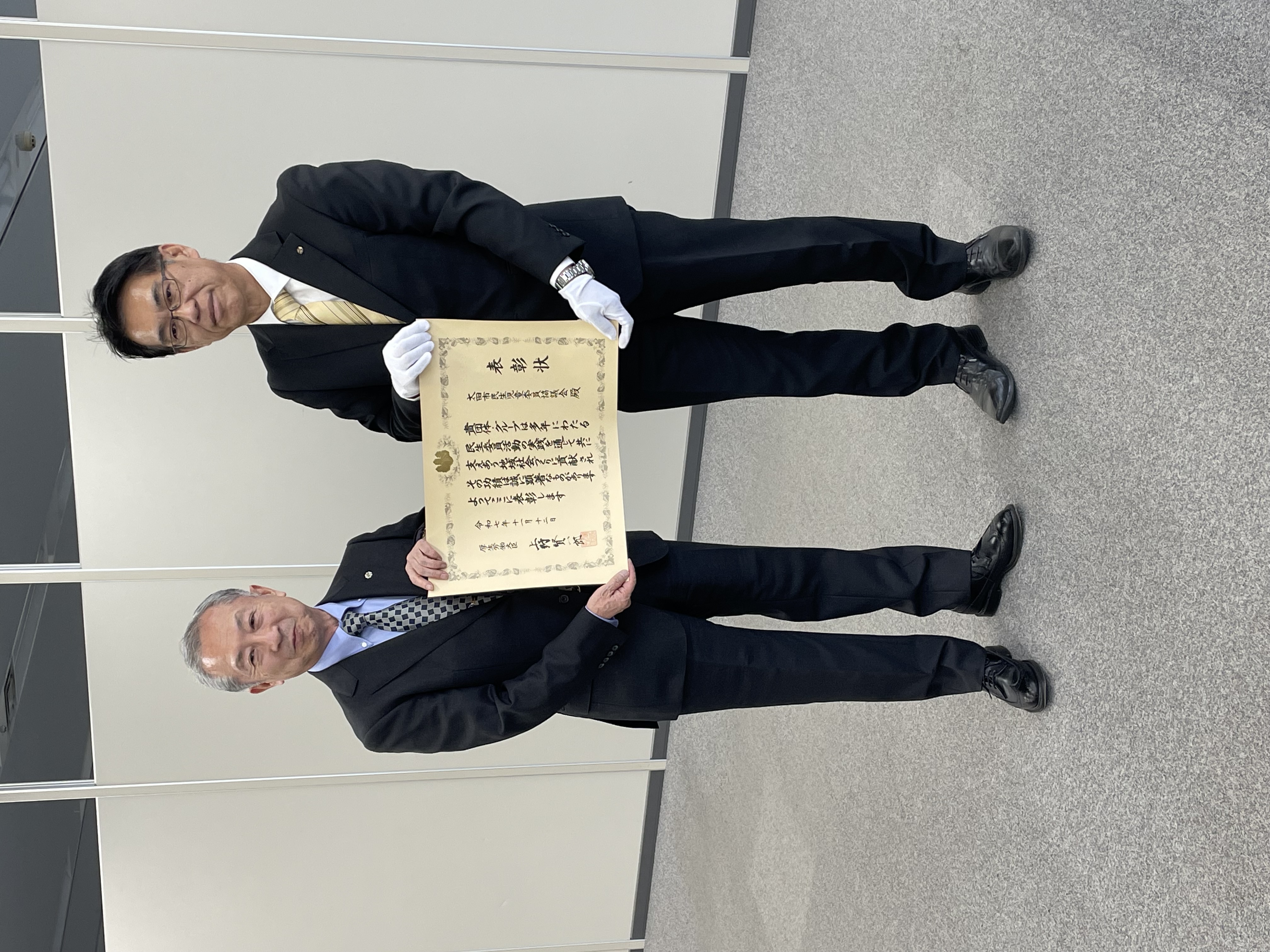 賞状を持つ群馬県地域福祉課長と太田市民生児童委員協議会長